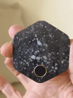 Hand holding black terrazzo hexagonal object