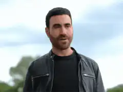 Sacha Baron Cohen smirking and looking around