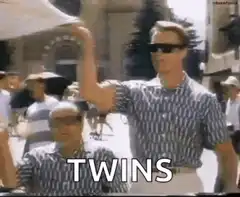 Two men in matching outfits labeled TWINS