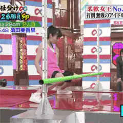 Woman does backbend under limbo stick