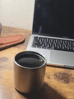 coffee cup next to laptop