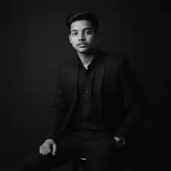 Man in black suit sitting on stool