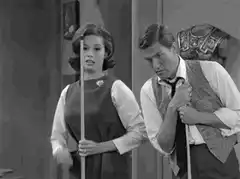 Man and woman holding pool cues