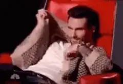 Adam Levine laughing and covering face