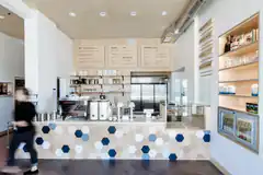 blurred person walking past hexagonal tile counter