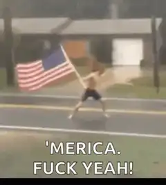 Shirtless man waving flag in rain