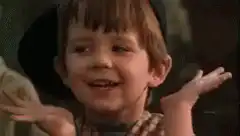 Young boy shrugging and smiling