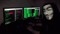 Guy in Guy Fawkes mask typing code