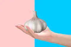 Hand holding garlic bulb then cloves