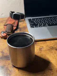 Steaming metal cup on desk