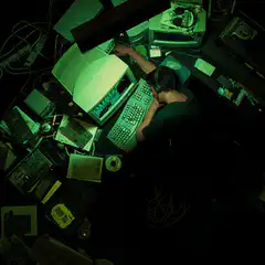 Man sleeping at messy computer desk