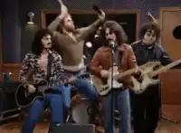 Band member plays drums with spatulas