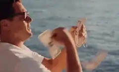 Leonardo DiCaprio throwing money into the ocean