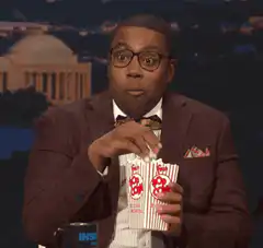 Comedian eating popcorn with wide eyes
