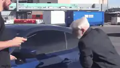 Old man points gun at car but not at himself