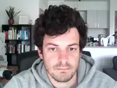 Man in grey hoodie looking at camera