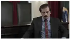 Man in suit raises hands in triumph