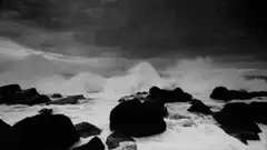 black and white ocean waves crashing on rocks
