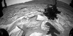 Mars rover arm moving over rocks