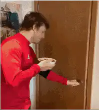 Man in red sweater opens door and falls