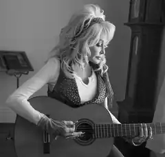 Dolly Parton playing acoustic guitar