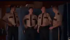 Four police officers laughing in the locker room