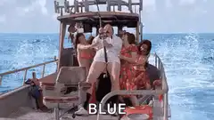Woman on boat holding selfie stick with 'BLUE' text