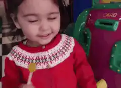 Little girl laughing with lollipop