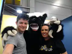 Couple posing with a furry monster mascot
