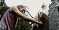 Old man carving a statue