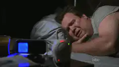 man sleeping with alarm clock