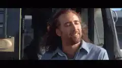 Nicolas Cage smiling in a blue shirt