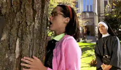 Nun watching girl kiss tree
