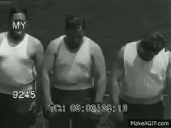Three men in tank tops turn around