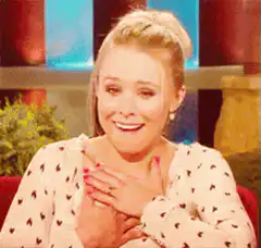 Kristen Bell touching her chest