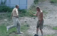 Two shirtless men practicing martial arts moves