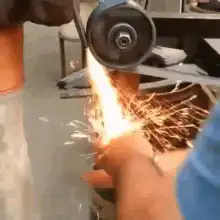 Hand held against angle grinder sparks