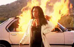 Woman standing in front of burning car