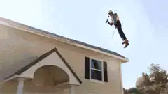 roofer on roof with mission accomplished sign