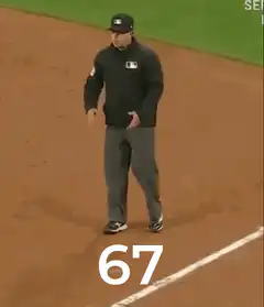 Baseball umpire shrugs with number 67