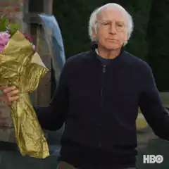 Larry David holding flowers saying I'm so sorry