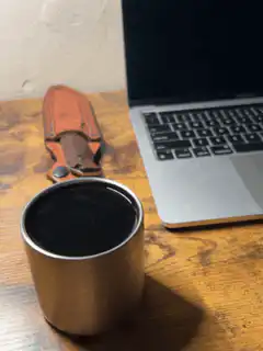 Coffee cup on desk with laptop and knife