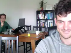 Two men at a table, one giving thumbs up