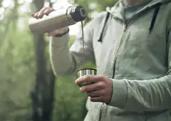 person pouring coffee outdoors