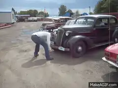 Man pushing vintage car