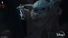 Baby Yoda cheers with a drink