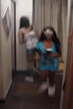 Two girls in a hallway, one with a blindfold