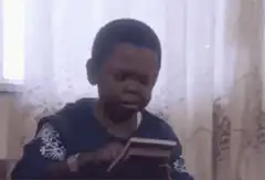 Boy reading book and laughing
