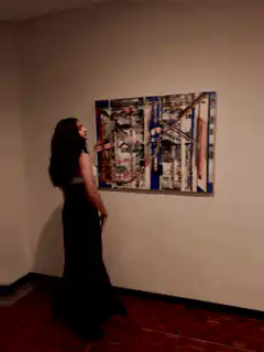 Woman in black dress posing in art gallery