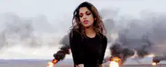 Woman dancing in front of burning tires